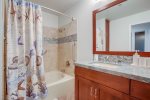Bathroom with large oval tub/ shower combination, a bide, mirror, and dual vanity sinks.